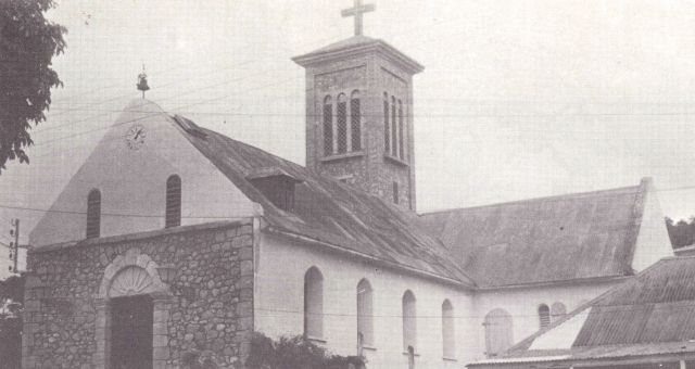 Façade, transept et clocher en pierre : œuvre du Père Offrédo